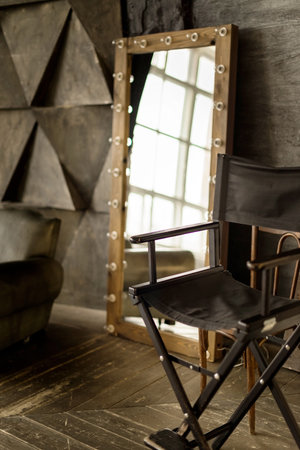Empty chair in hair dressing salon and mirror on the wall with light reflectionの写真素材