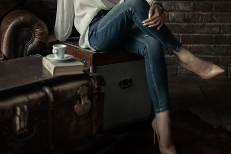 Elegant woman in slim blue jeans sitting with her legs crossedの写真素材