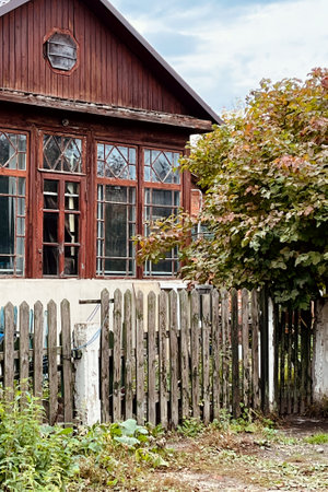 old wooden house with terrace behind fenceの写真素材