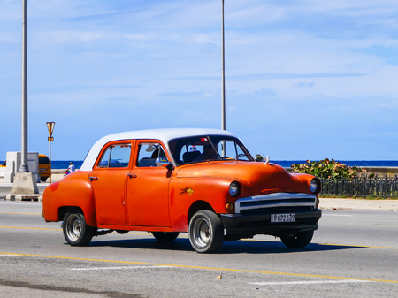 Vintage orange car driving along the Malecon (Havana, Cuba).のeditorial素材