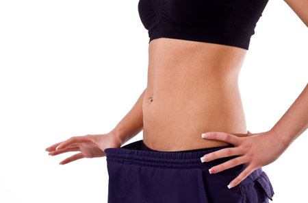 Slim young girl in big old pants showing weight loss.の写真素材