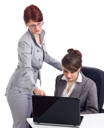 Two young businesswoman with laptop isolated over whiteの写真素材