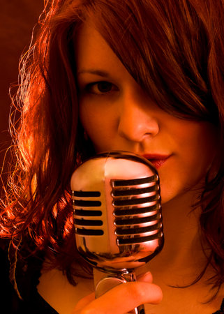 Sexy singer with retro microphone in strobe light の写真素材