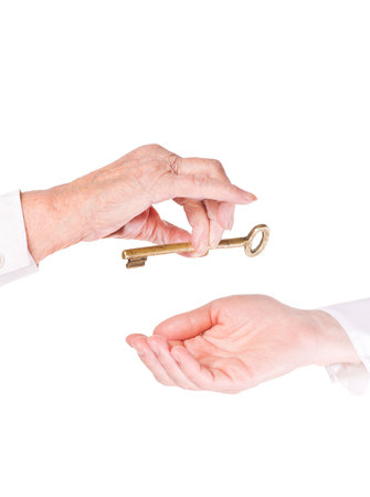 Old woman handing keys to younger womanの写真素材