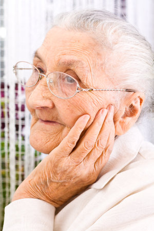 Old woman at the window, dreaming the pastの写真素材