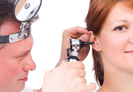Doctor using otoscope to look in a girlの写真素材