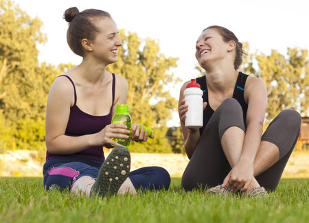 Two girls having a rest, drinkingの写真素材