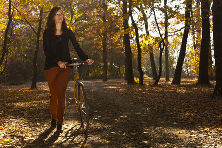 Beautiful girl with bicycle in parkの写真素材