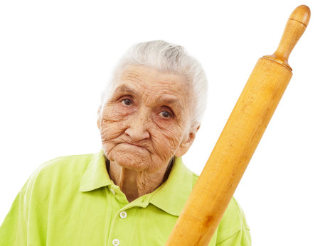 angry old woman holding a rolling pin in her handの写真素材