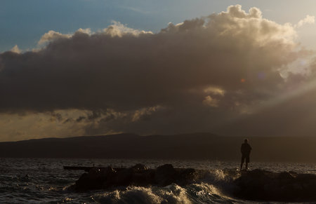 man standing on the shore at duskの写真素材