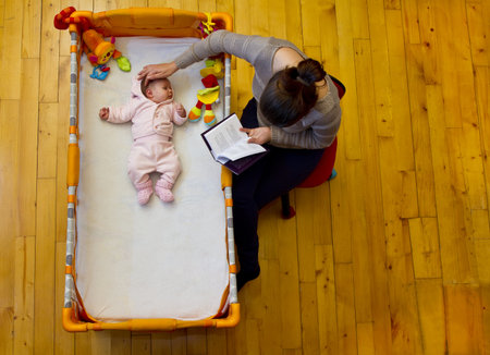 mother soothing her baby with reading and strokingの写真素材