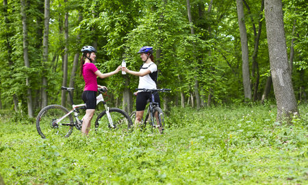 two girls having a break during cycling  in the forestの写真素材