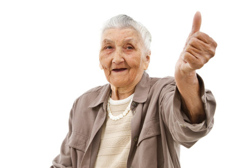 old lady showing thumbs up in front of an isolated backgroundの写真素材