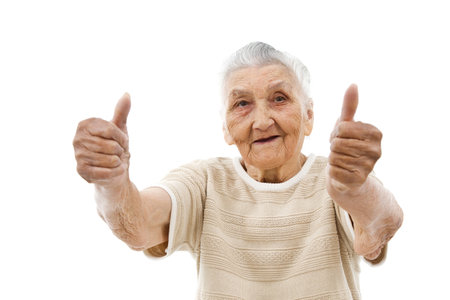 old lady showing thumbs up in front of an isolated backgroundの写真素材