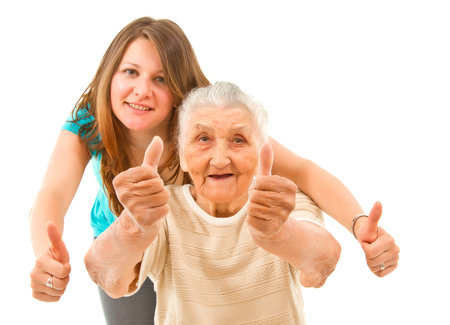 young woman with her grandmother showing thumbs up on an isoltad backgroundqの写真素材