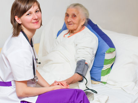 Happy joyful nurse caring for  an elderly woman  helping her days in nursing home.の写真素材