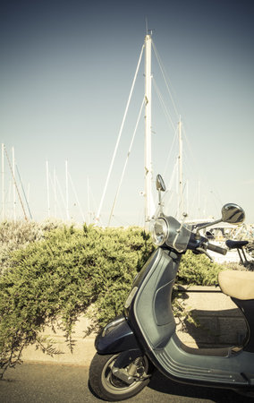 vintage green scooter in the harbour, with spars in backgroundの写真素材