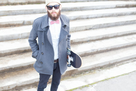 Portrait of a hipster young boy holding a skateboard.の写真素材