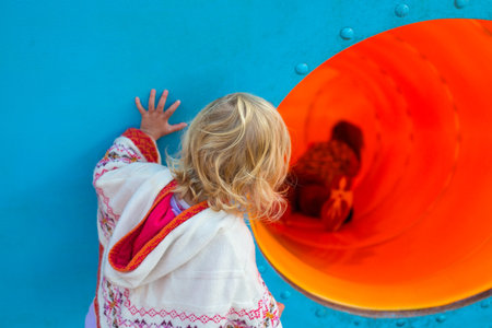 Little girl looking at other children playing.の写真素材