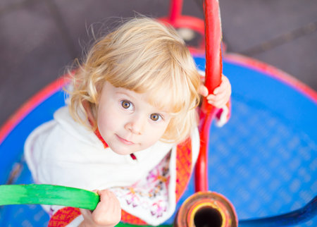 Little blond girl with brown eyes playing.の写真素材