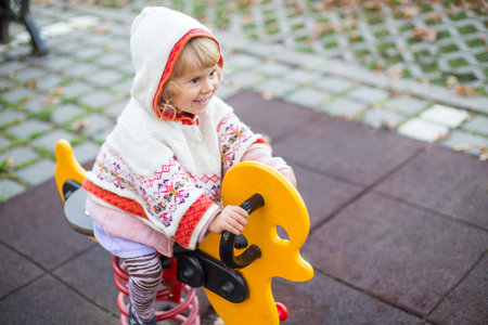 Beautiful little girl laughing and playing in the playground.の写真素材