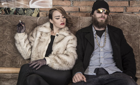 Rich couple sitting on a couch at home.の写真素材