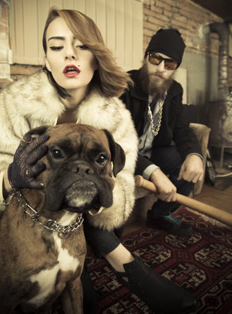 Portrait of an aggressive couple with their strong dog in the house.の写真素材