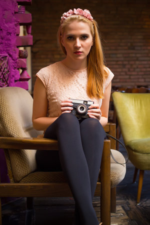 Beautiful blond lady holding a retro camera.の写真素材