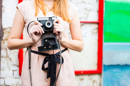 Pretty young girl holding an old camera.の写真素材