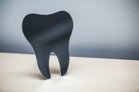 Black tooth shaped object symbolizing dental care.の写真素材
