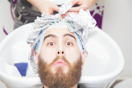 Process of a guy having his hair dyed at hairdresser.の写真素材