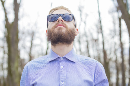 Hipster guy showing how to wear beard, hair and glasses with genuine style.の写真素材