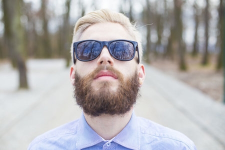 Portrait of a dyed blond hipster guy with  black sunglasses.の写真素材
