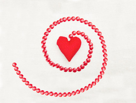 Buttons surrounding heart shaped pillow over white background.の写真素材