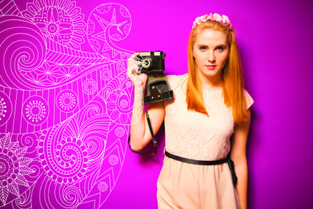 Woman with camera, pink backgroundの写真素材