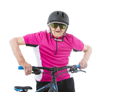 Elderly woman in pink shirt with a bikeの写真素材