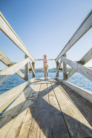 Plank on the water with a blond little girlの写真素材