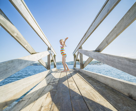 Plank on the water with a blond little girlの写真素材