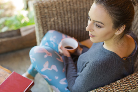 young woman holding a cup of coffeeの写真素材