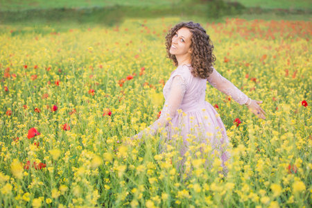 curly haired woman in the poppy meadowの写真素材