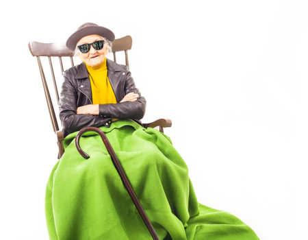 Old woman with sunglasses sitting on a chair.の写真素材