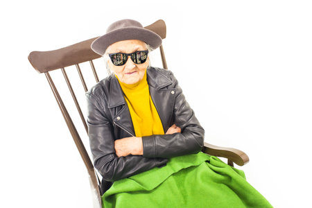 Old woman with sunglasses sitting on a chair.の写真素材