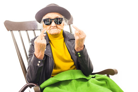 Old woman with sunglasses sitting on a chair.