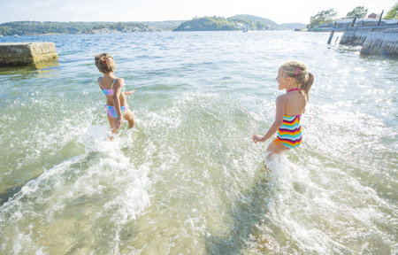 young girls enjoy playing in the seeの写真素材