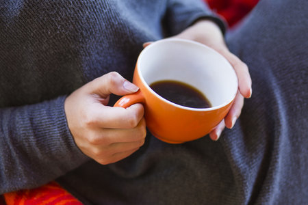 woman hands holding a cup of coffeeの写真素材