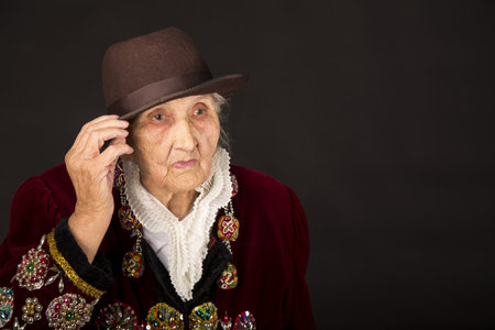 Old woman wearing a vermilion velvet jacket
