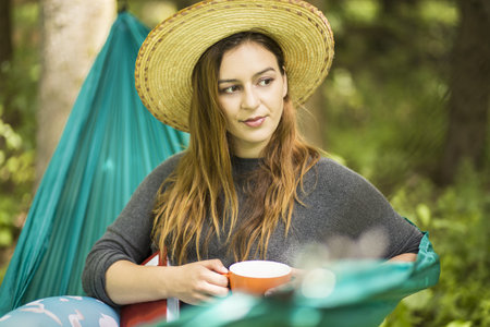 beautiful young woman in a green hammockの写真素材