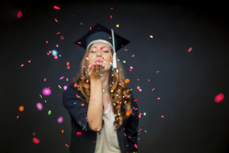 Confetti girl with graduation hat and black backgroundの写真素材