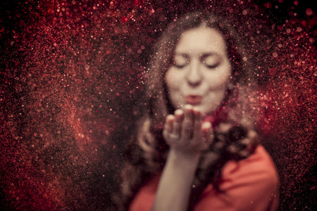 Colorful glitter blown by a young girlの写真素材