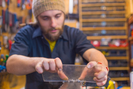 Bearded guy doing handicrafts in the workhop